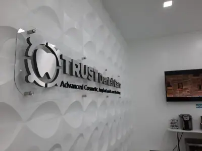 Logotipo dimensional en muro texturizado de recepción · TRUST Dental Care